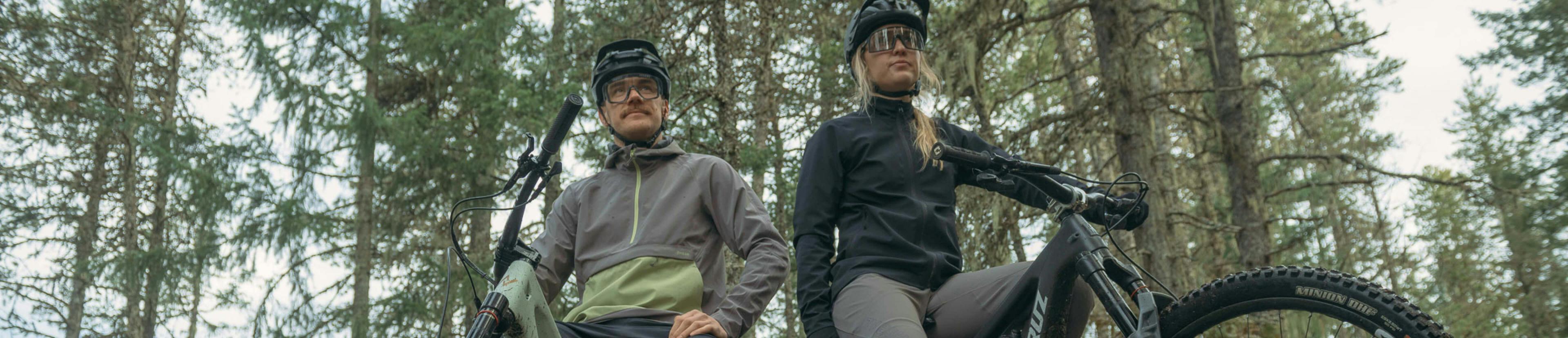 Man and woman wearing cool jackets sitting on bikes